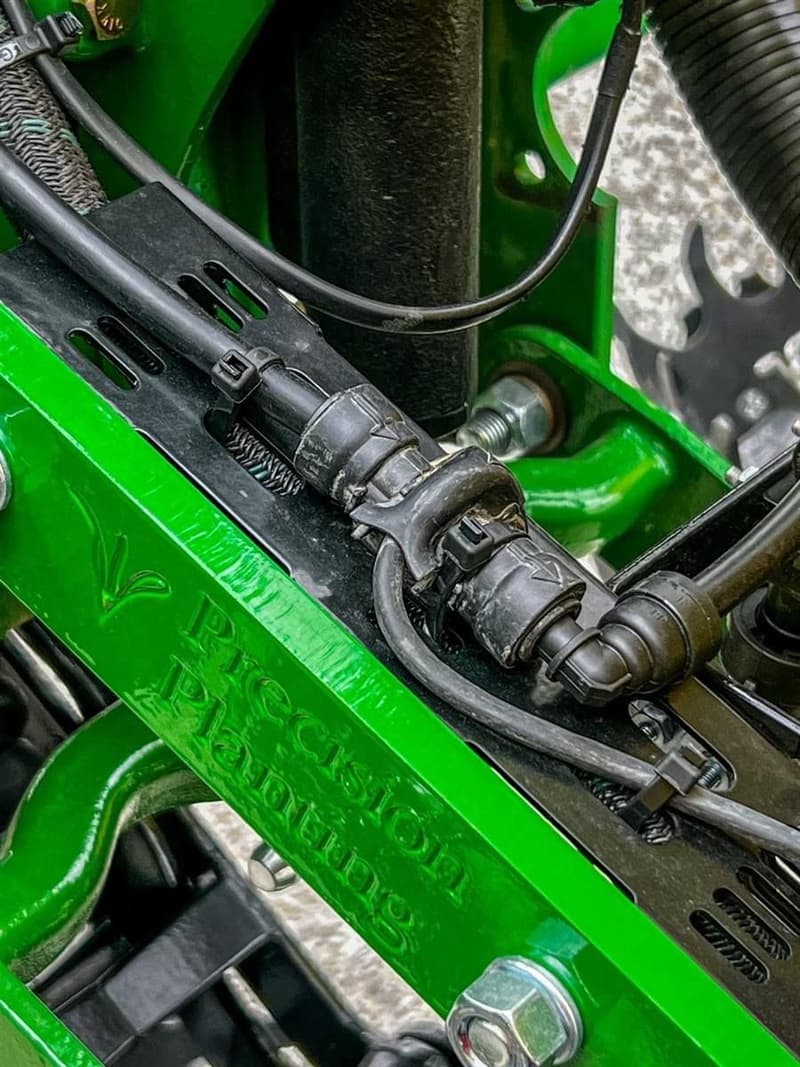 Wiring harness routed and clipped on a green row unit