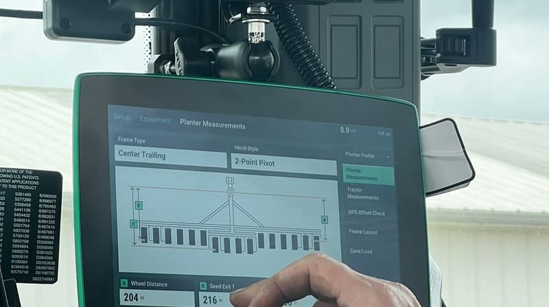 Hand tapping the Precision Planting 20|20 monitor in the cab