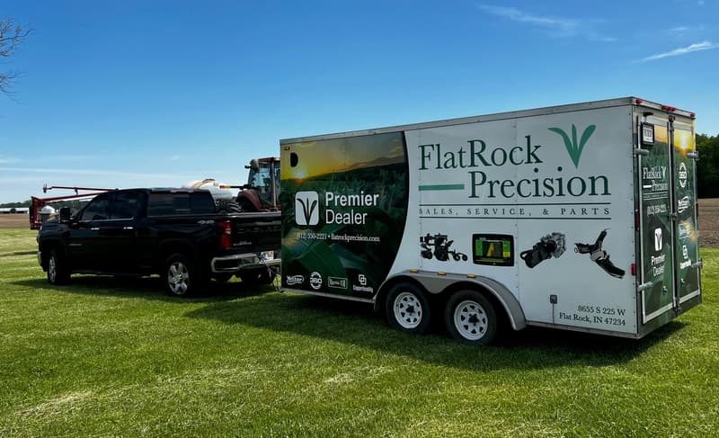 Flat Rock Precision Premier Dealer trailer and pickup parked in the grass