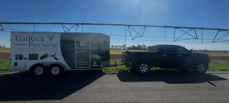 Flat Rock Precision pickup and trailer on the road under a center pivot