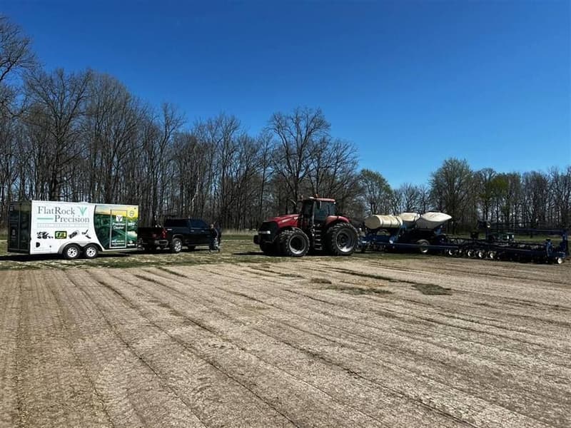 Trailer parked at the grower's field. Setup and answers happen where the planter is.